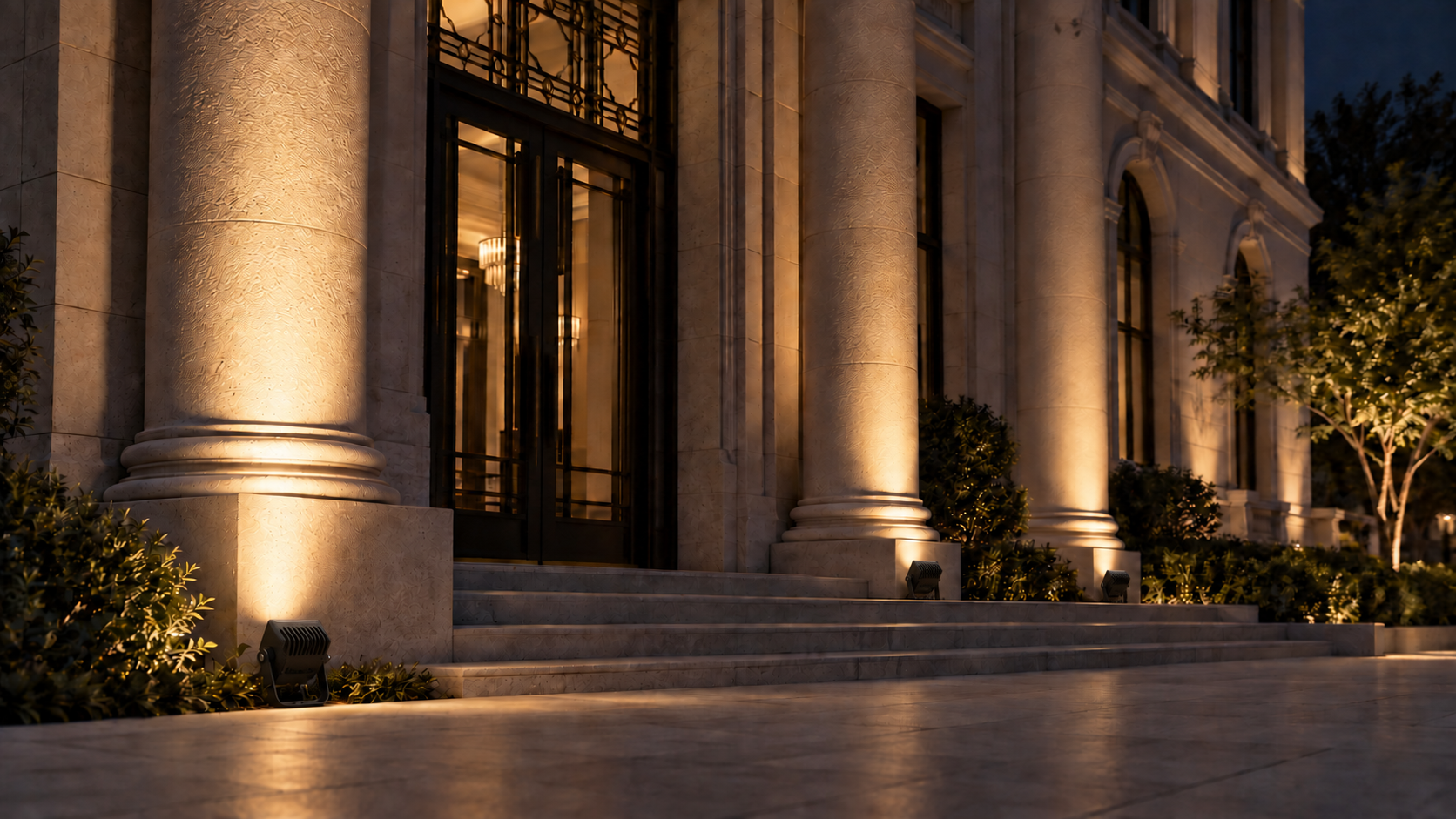 Application illustration — each visible floodlight is oriented with its emitting face toward the corresponding facade column.